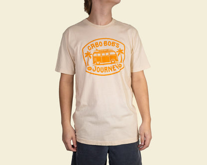 A person wearing a beige t-shirt with 'CABO BOB'S JOURNEYS' printed in orange on the front.